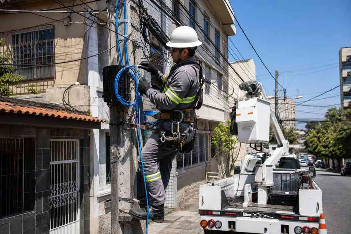Técnico instalando cabo de fibra óptica em residência no bairro Aclimação